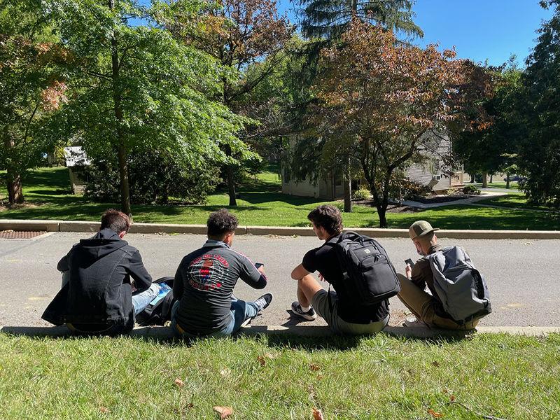 photo of Male students sitting outside 